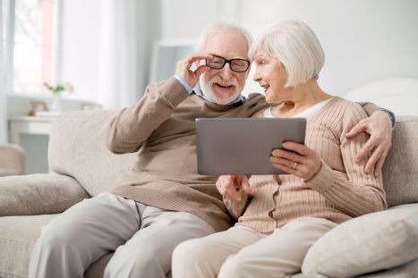 Foto: altes Ehepaar auf Couch mit Tablet